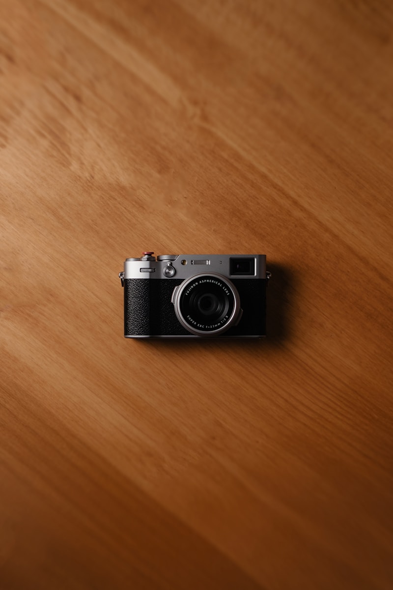 A vintage camera rests on a wooden surface.